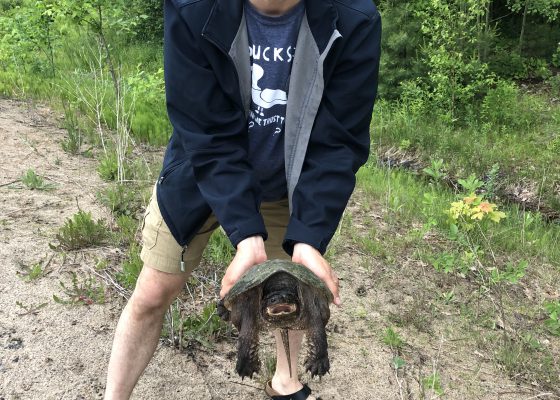 A man holding a snapping turtle.